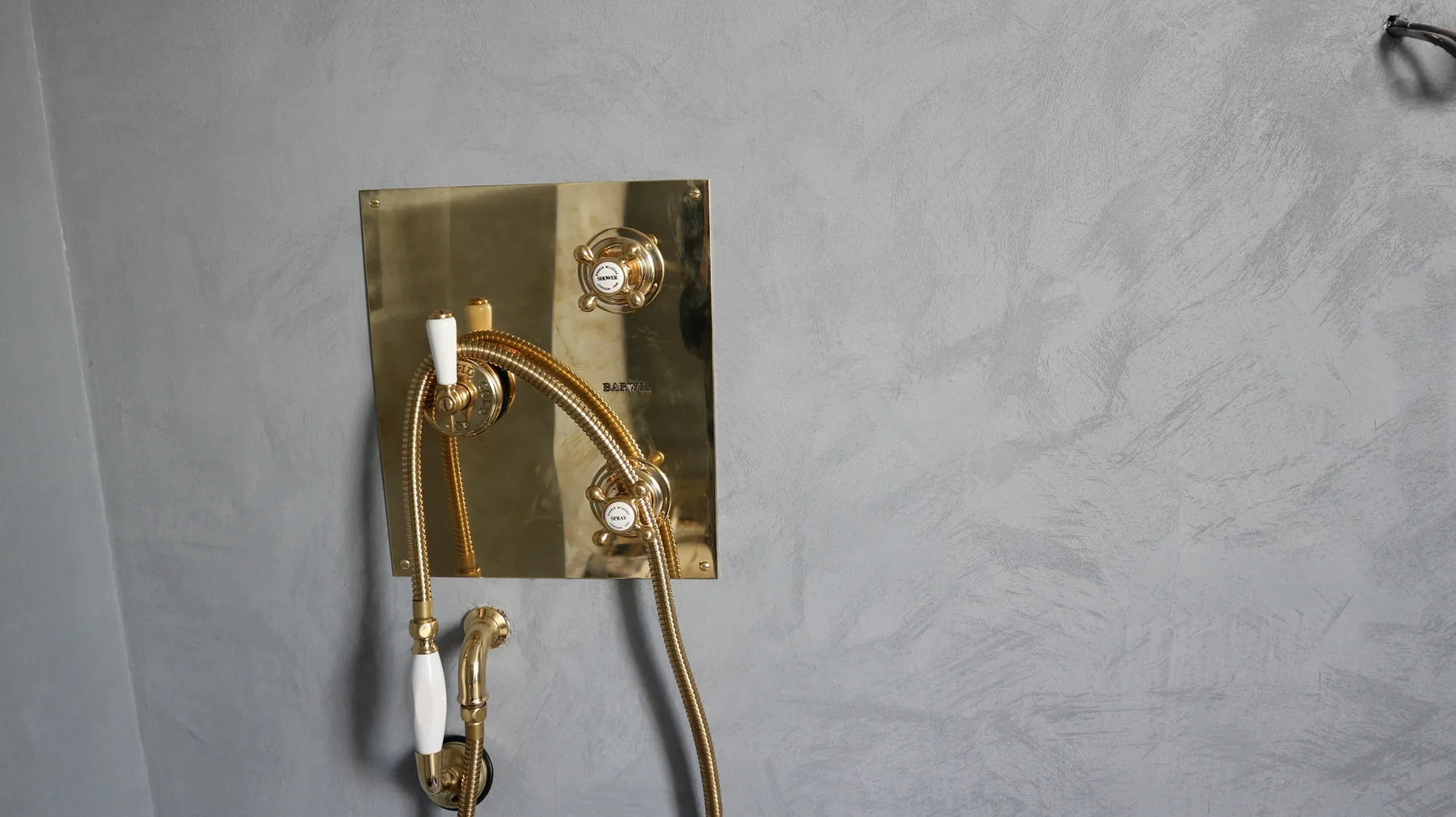 Microcement shower wall with brass panel