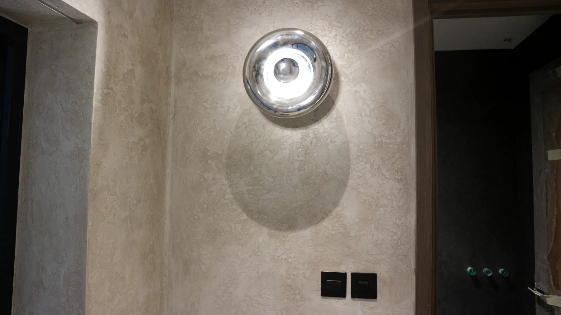 Pearlescent plaster wall with round wall light